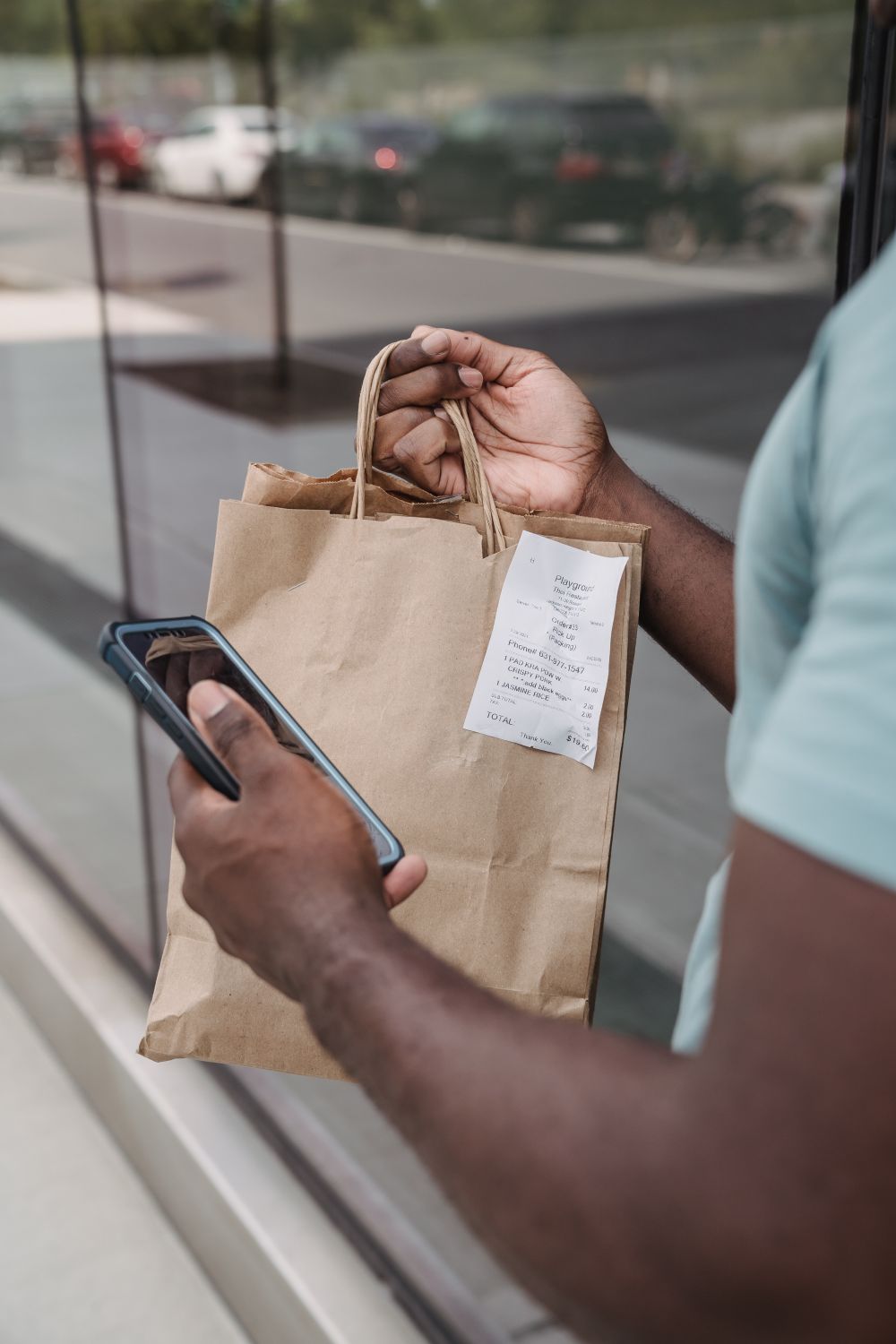 Xarid sumkasi va telefon ushlagan xaridor